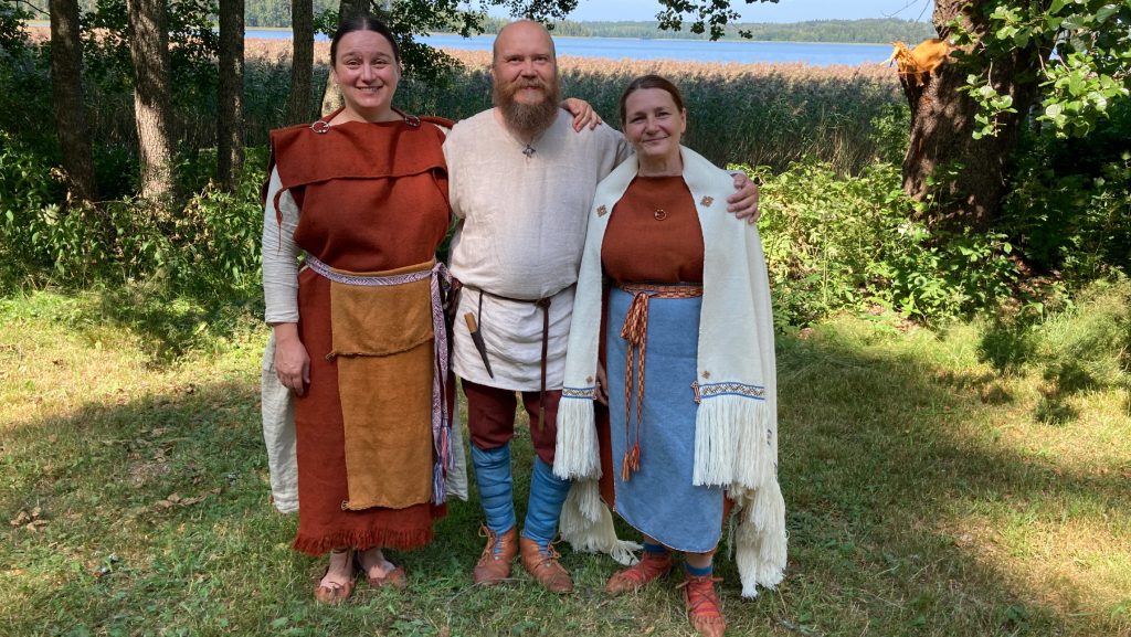 Kolme ihmistä muinaispuvuissa.