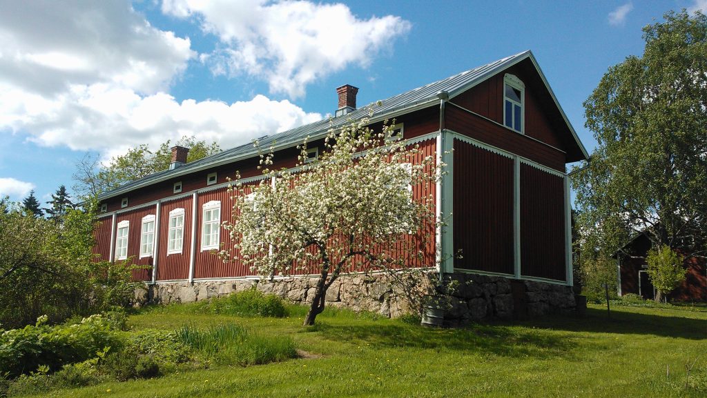 Punainen pohjalaistalo kesällä.